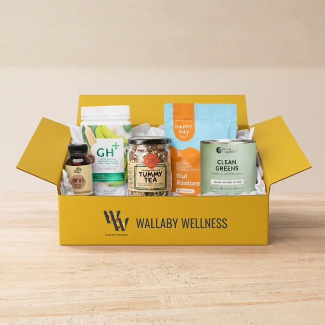 Open yellow box from Wallaby Wellness containing Gut Health Starter Pack on a wooden surface.
